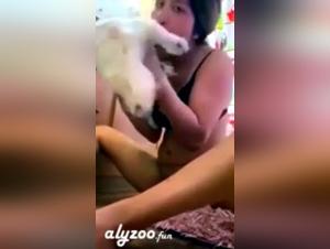 Eine junge Frau leckt ihren kleinen Hund vor der Webcam
