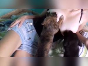 Mujer voluptuosa, enseñando amamantando a dos pequeñas cachorras